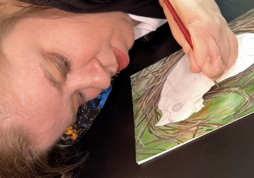 Artist Katherine Klimitas drawing a detailed nature-inspired illustration.